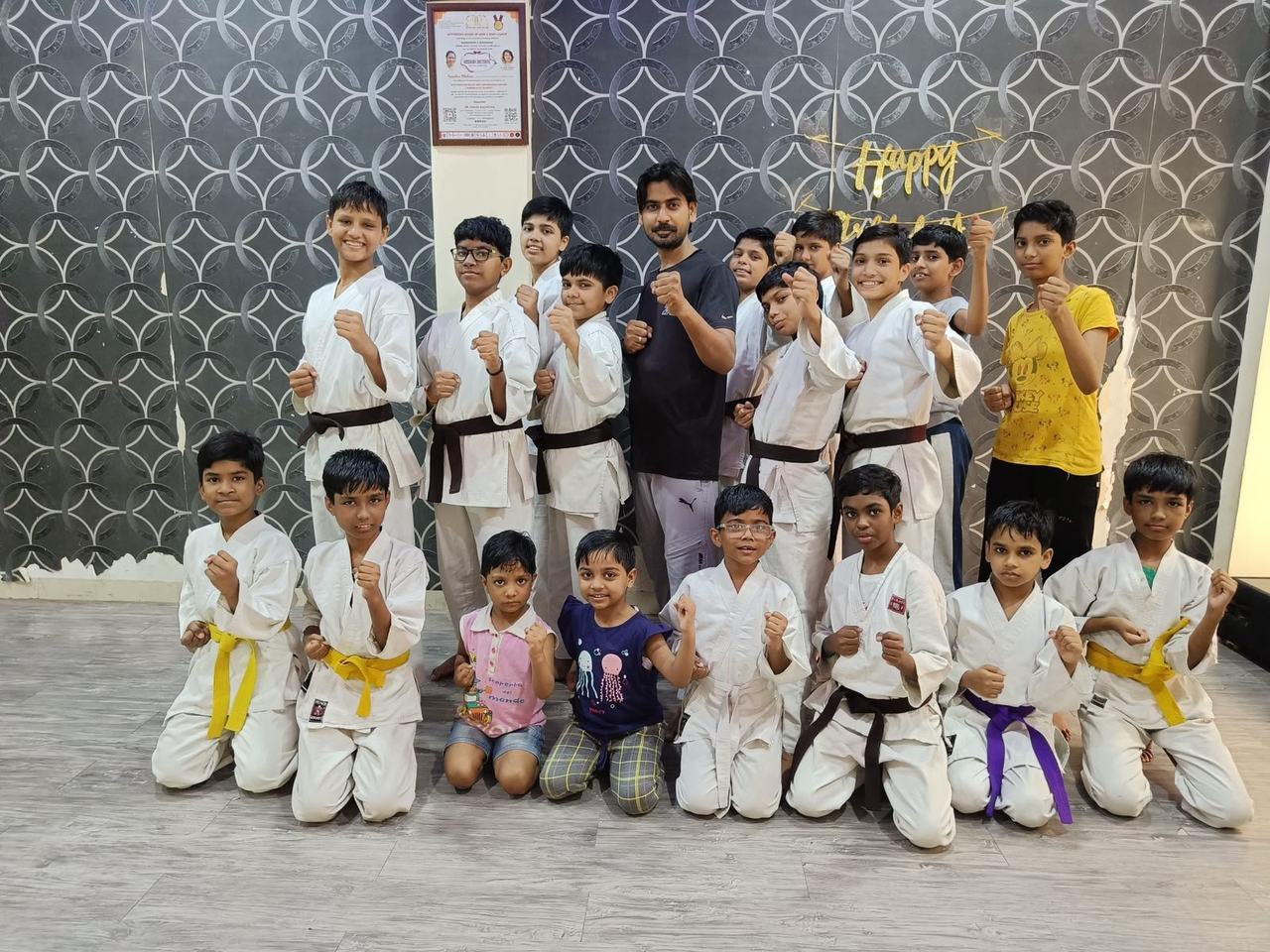 A karate class posing together in training uniforms