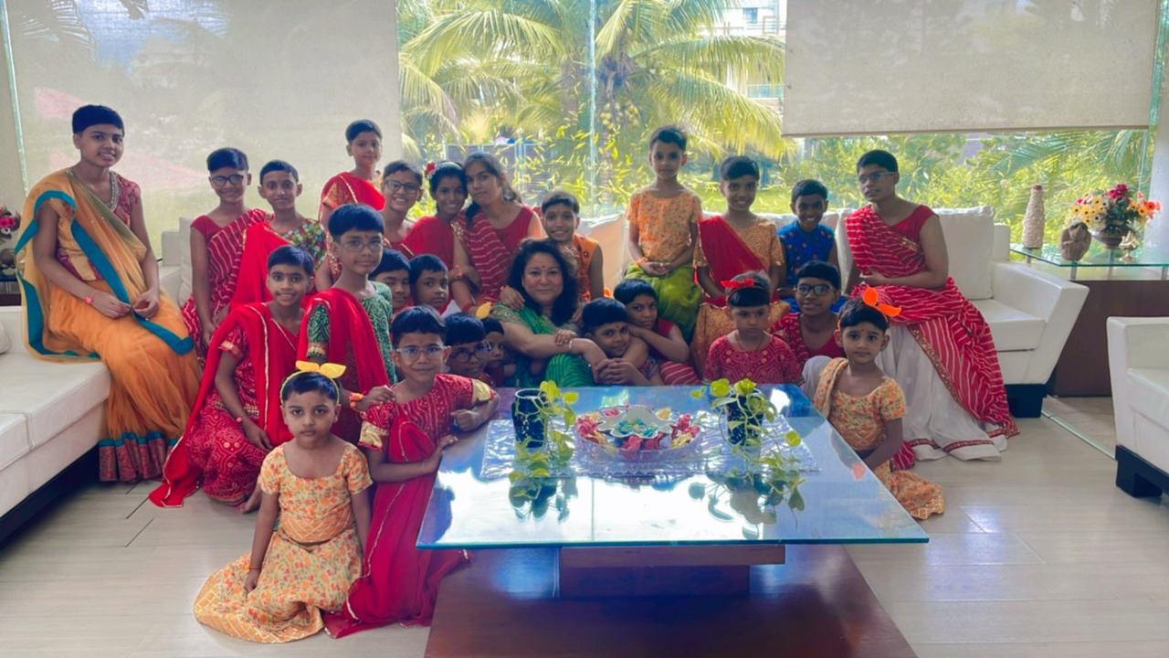 Children in festive attire with founder Sumitra Mishra