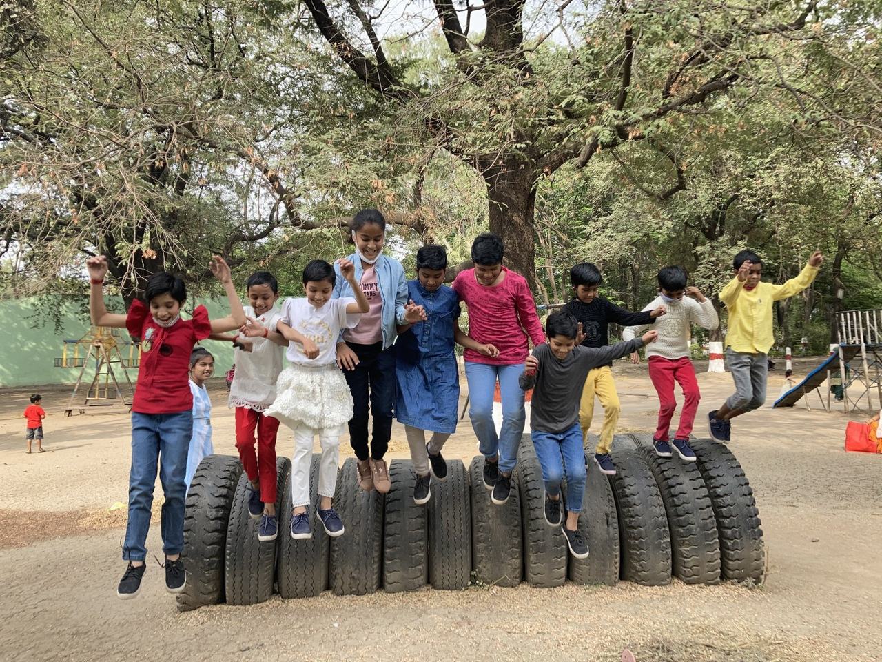 Children on an outdoor tyre obstacle course