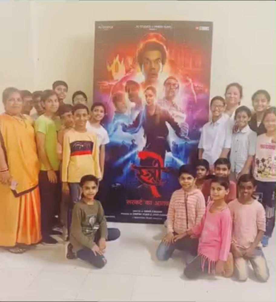 Girls from Aanchal Home posing with a movie poster on a cinema outing