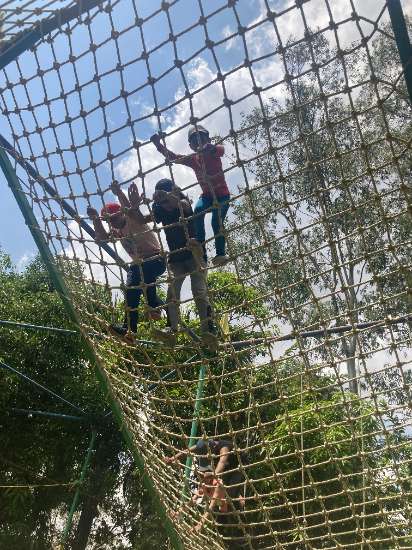 Children climbing a net structure outdoors