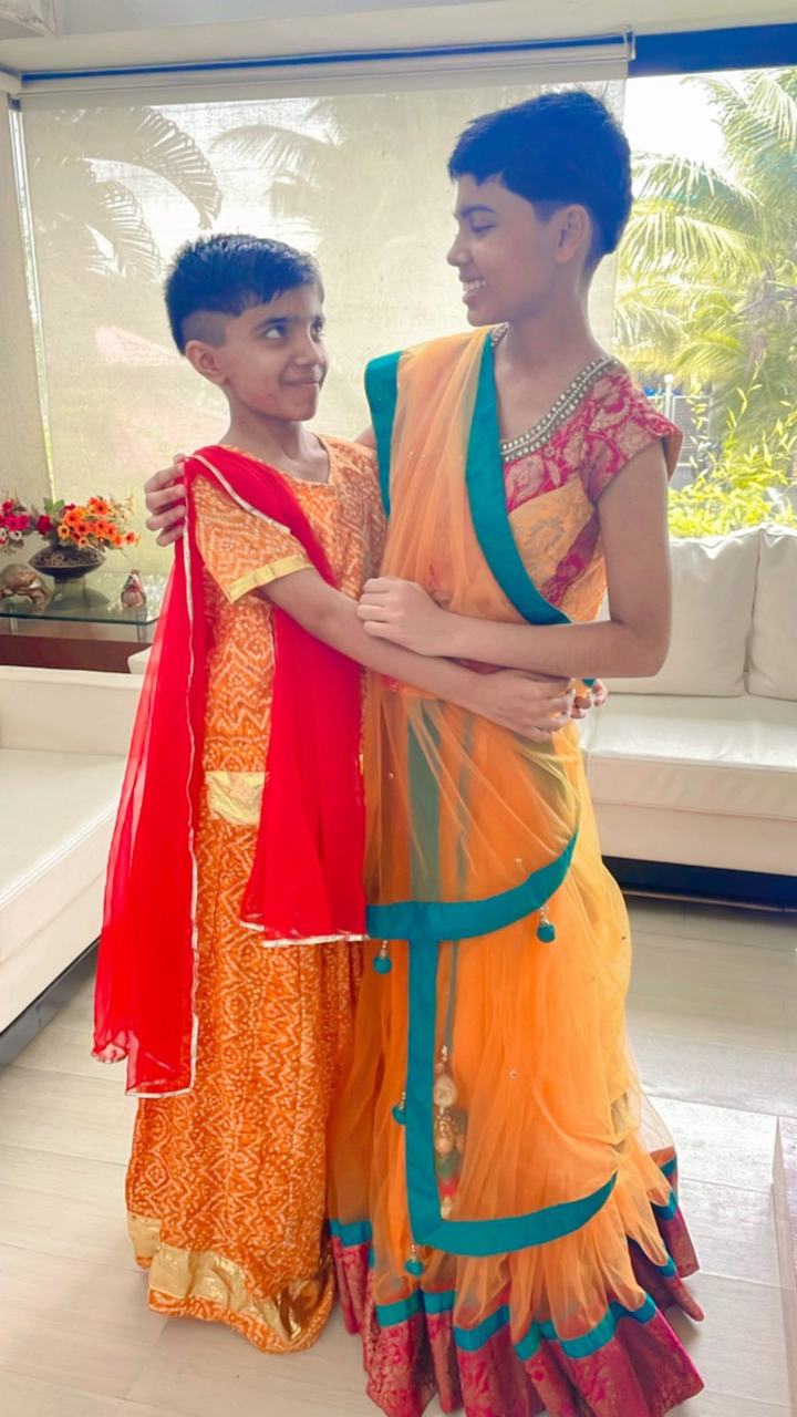 Two boys posing in festive orange costumes
