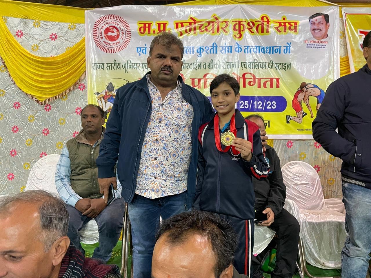 A Shiv Karmsthali girl receiving a gold medal at the State Wrestling Championship